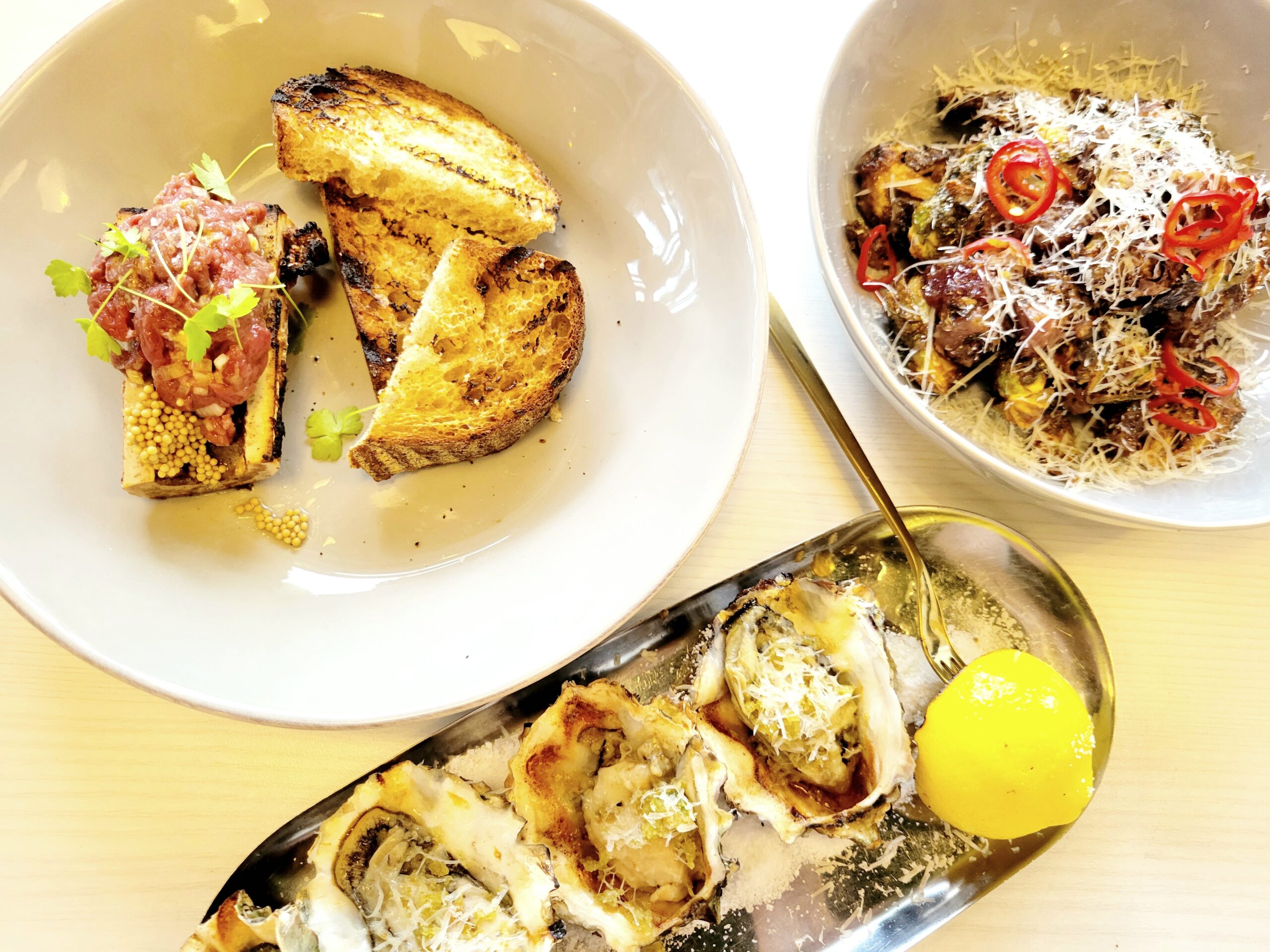 white table with oysters, toast and bone marrow