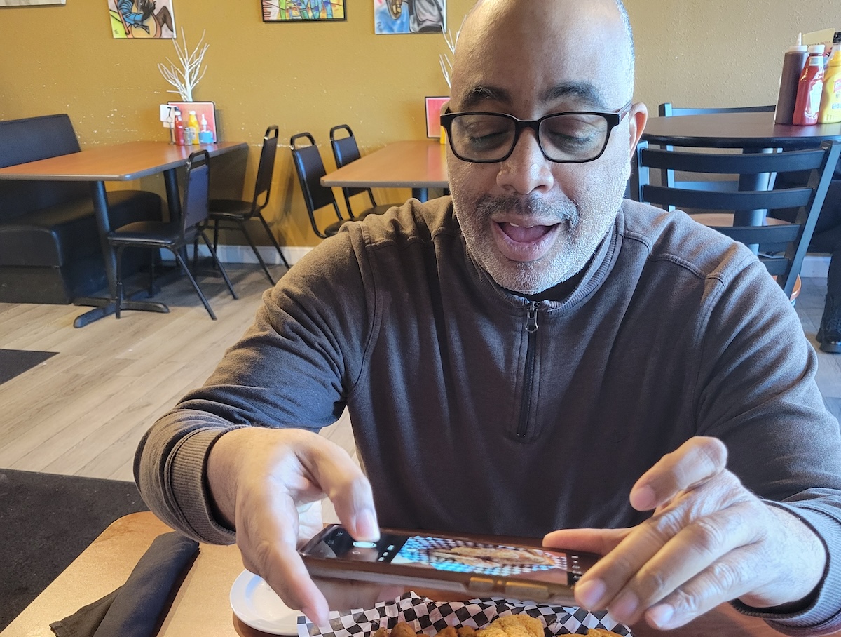 man taking pictures of food with a cell phone